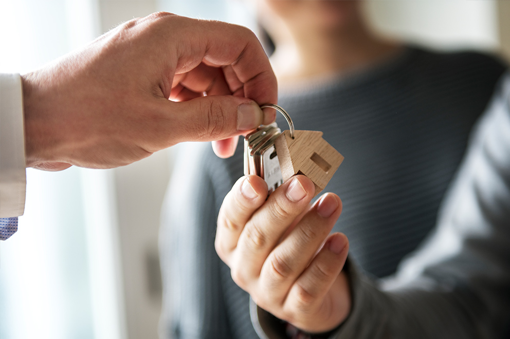 Hands passing house keys