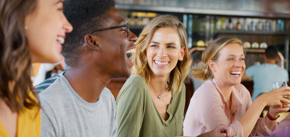 Group of people laughing and enjoying dinner